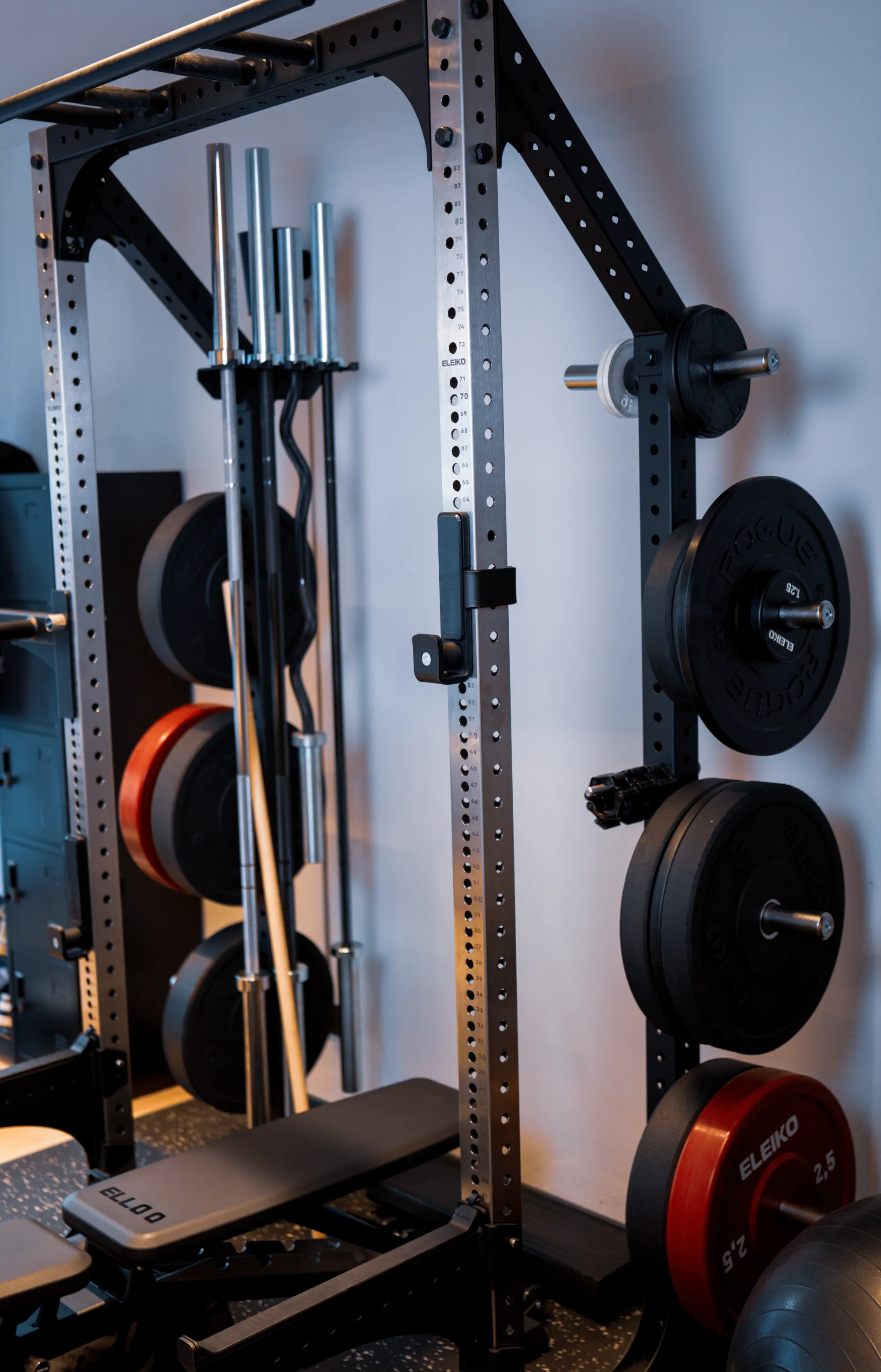 Rack mit Langhantel und Hantelscheiben an der Wand