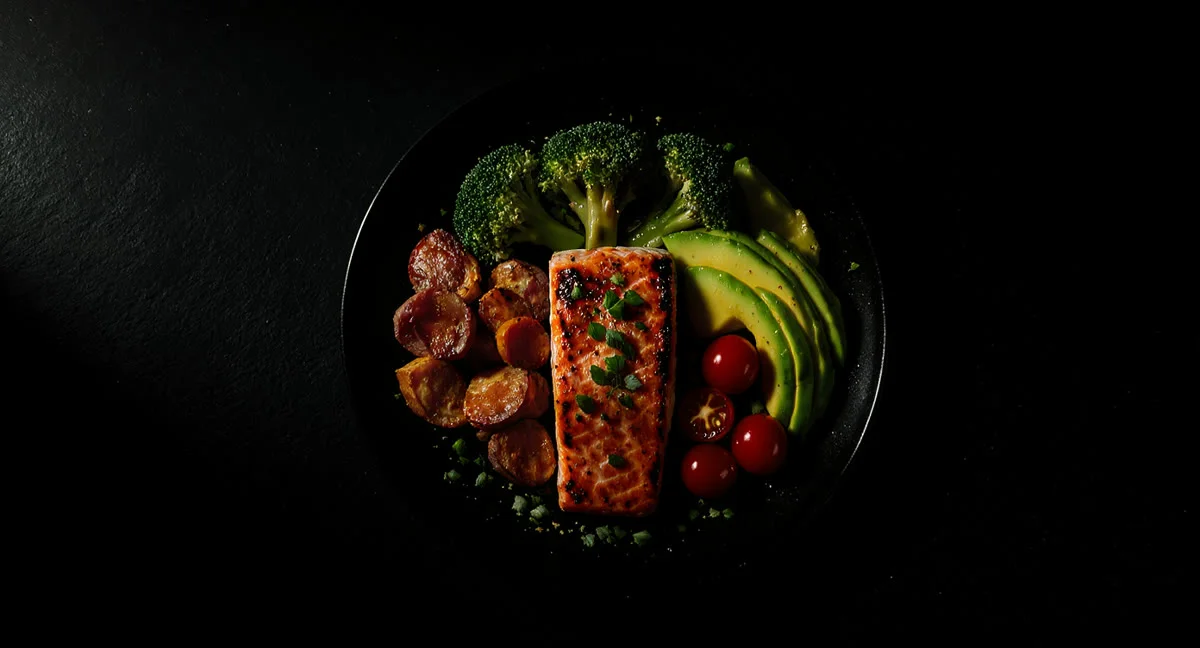 Ausgewogene Mahlzeit mit Lachs, Brokkoli, Süßkartoffel und Avocado